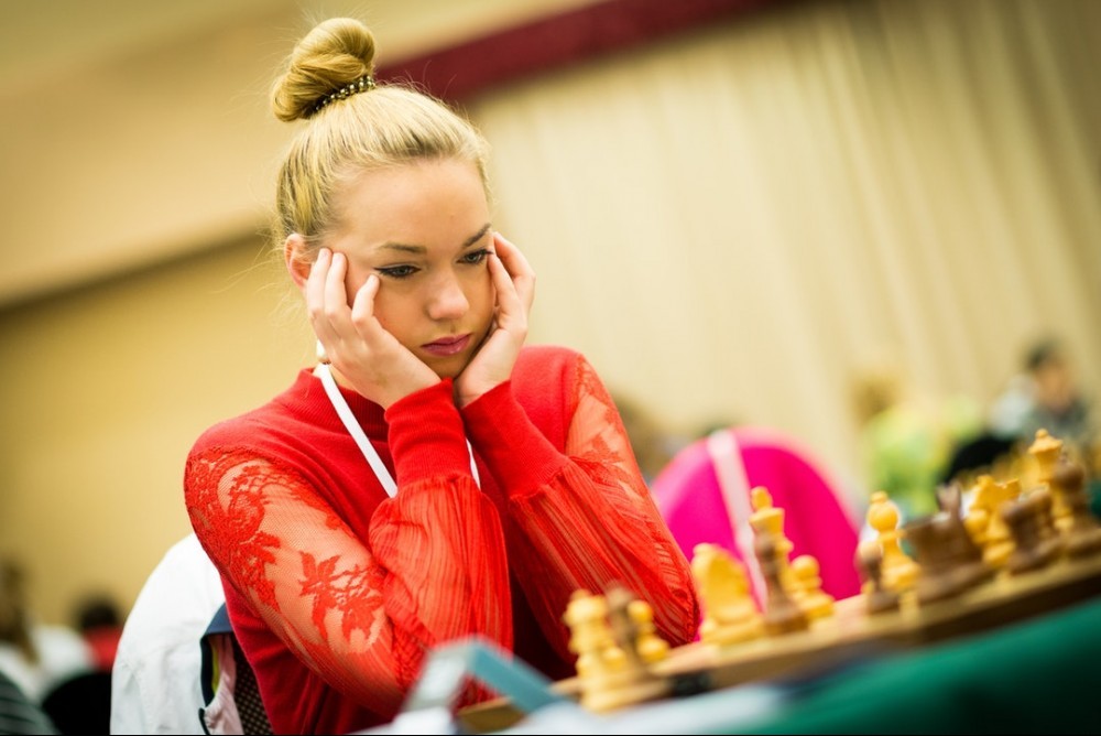 woman puzzling over a chessboard