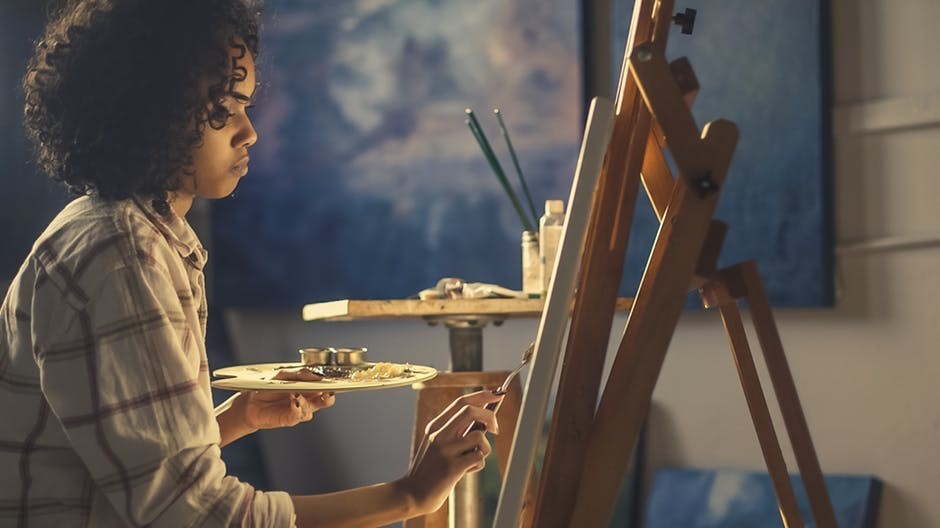 black woman painting in studio