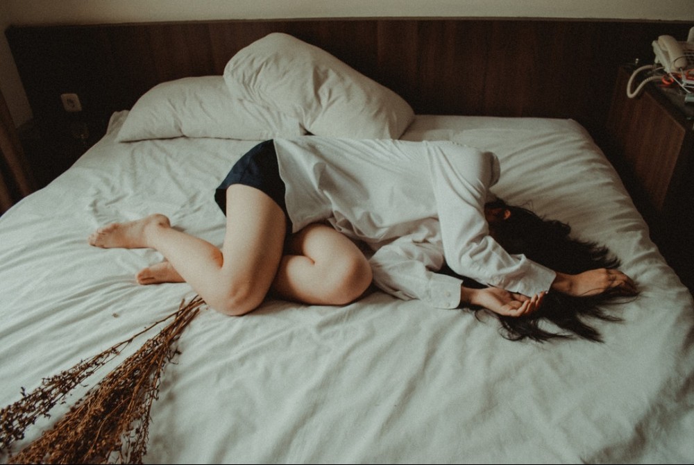 exhausted woman sleeping on bed