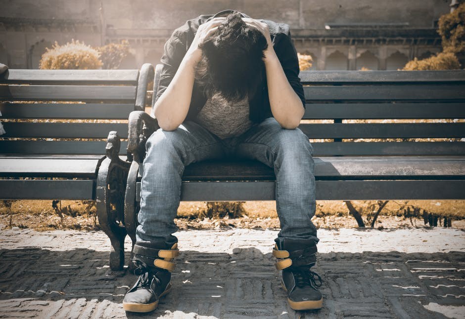 man on bench with head down