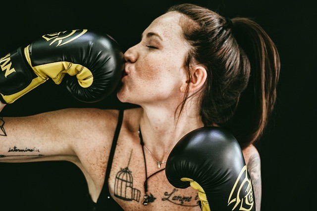 woman in wearing boxing gloves and exercising