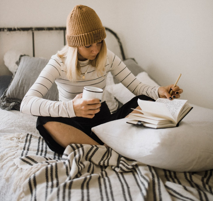 woman journaling on her bed